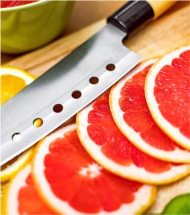 Chef knife, sliced blood orange on a cutting board