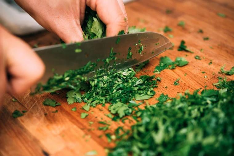 Chef knife, chopping herbs on a cutting board