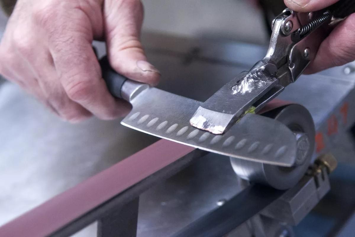 knife being sharpened on a belt sander